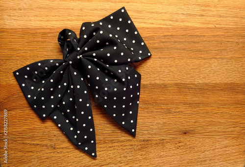 blue polkadot oversized pre-tied bow tie on a wood background