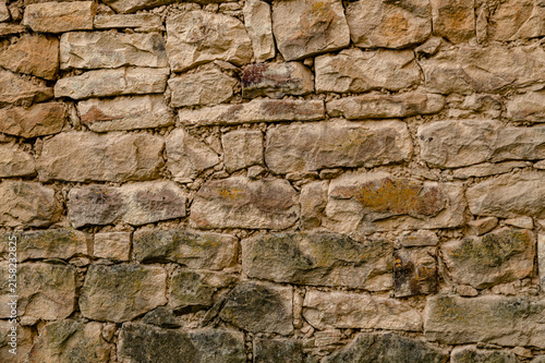 Bild auf Leinwand Weathered stone blocks form a textured rustic wall pattern