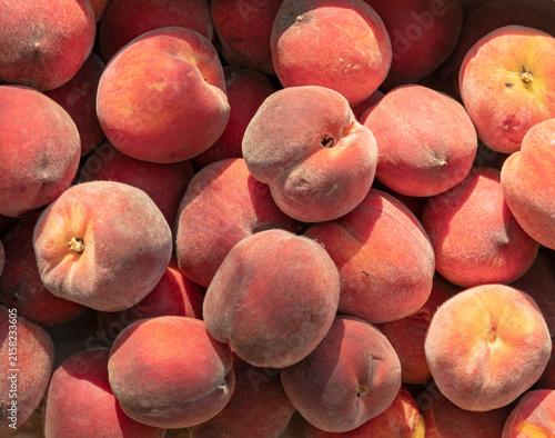 Ripe fuzzy peaches fill the frame with warm hues