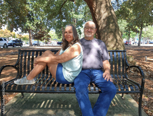 Happy Senior Couple Sitting Together on Park Bench