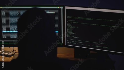 Mysterious male coder illuminated by a computer screen in a dark environment, creating a tense atmosphere associated with hacking, cybercrime, stolen information, digital espionage, and online fraud.