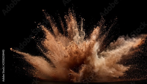 a dramatic explosion of dirt and debris creates a cloud of brown dust against a black background