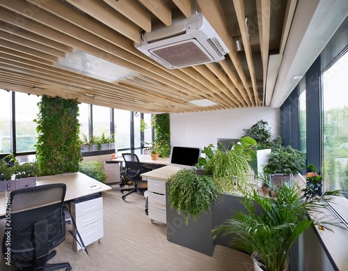 modern office with indoor greenery and ceiling mounted air conditioning unit