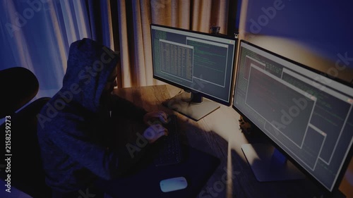 Shadowy figure works behind glowing displays in a secluded workspace, creating a tense visual of digital intrusion, compromised systems, online crime, unauthorized access, and modern inform security.