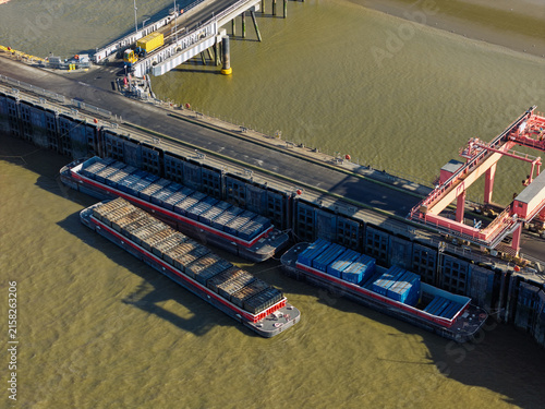 Barges Loaded With Waste Docked at a Power Station Facility During Daylight Hours