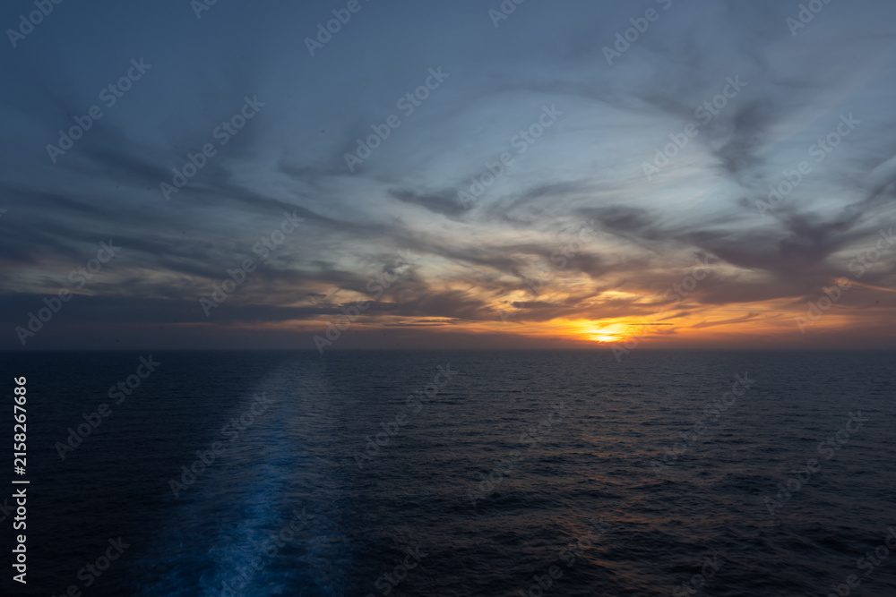 Obraz premium Sonnenuntergang von dem Heck mit dem Kielwasser eines Schiffes