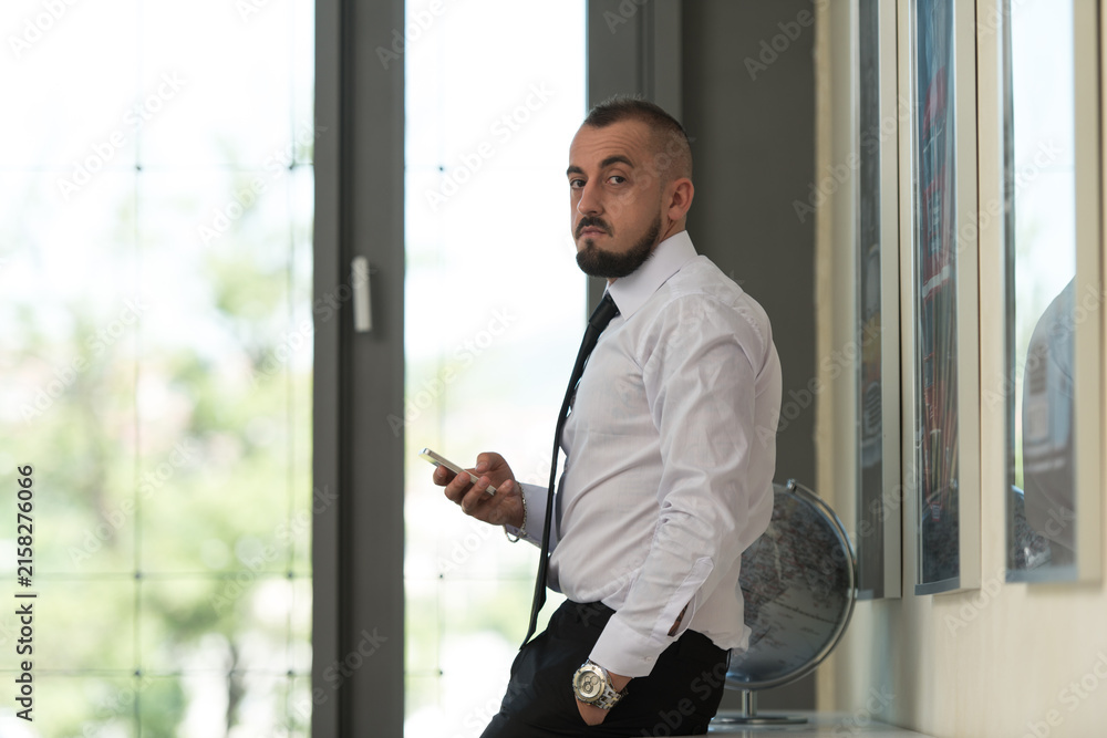 Fototapeta premium Business Man Texting On Cellphone In Modern Office