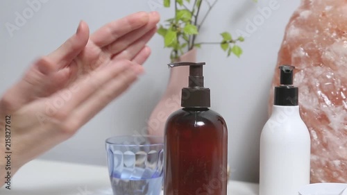 Liquid cream pumping. Woman relaxing her hand and wrist self massage as part of a wellness and self care routine at home. Female applying cream from tube to care moisturizing her palms skin
