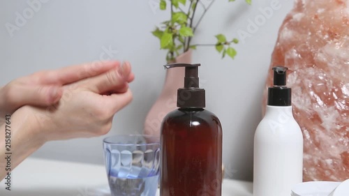 Liquid cream pumping. Woman relaxing her hand and wrist self massage as part of a wellness and self care routine at home. Female applying cream from tube to care moisturizing her palms skin