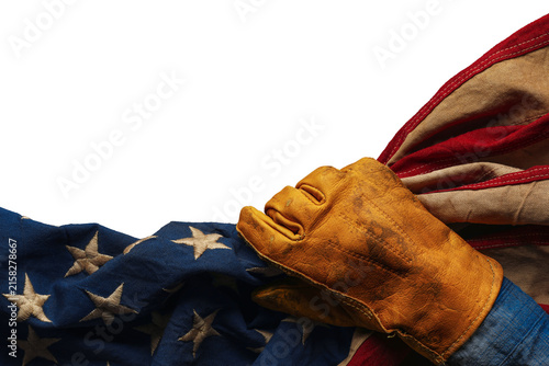 Worn work glove holding the American flag. Symbolic of hardworking blue collar workers, USA industries, pride in products Made in United States of America, or to celebrate US Labor Day. Isolated png.
