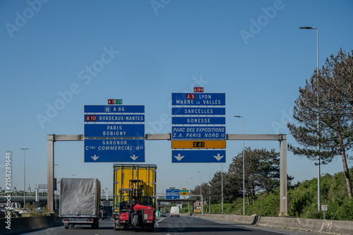 View of a French and European autoroute with overhead directional signs pointing to major cities like Paris, Bordeaux, Lille, Calais, showing lanes, traffic and motorway infrastructure, road signes