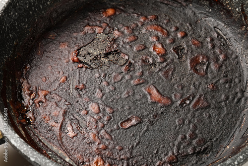 Quadro su tela Burnt food residue and grease in a dirty non-stick frying pan, kitchen cleaning