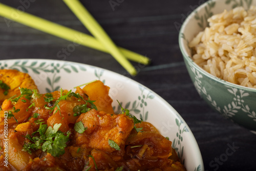 Stir fried chicken with a bowl of rice.
