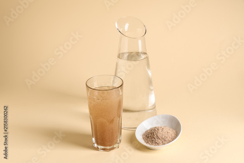 Cuadro en lienzo Glass of water with psyllium husk on beige background