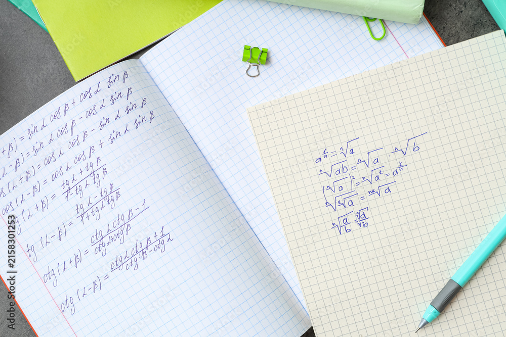 Fototapeta premium Copybooks with math formulas and stationery, closeup