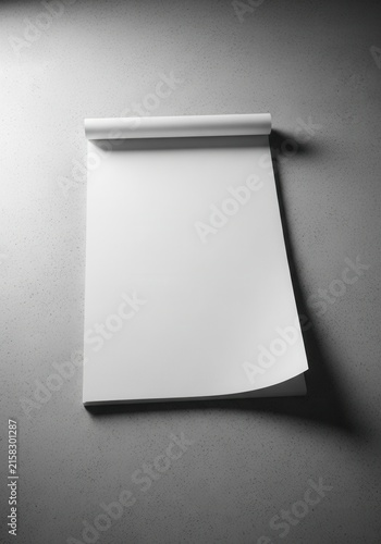 Blank white notepad on a smooth gray surface.