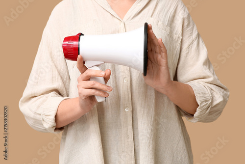 Obraz na płótnie Mature woman with megaphone on brown background