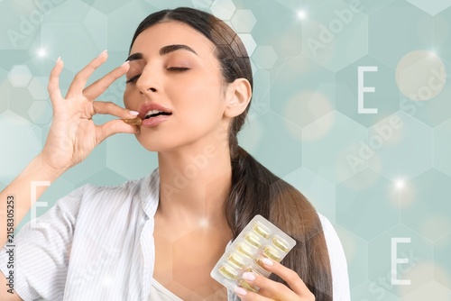 Young woman taking vitamin ...