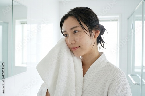 洗顔後にタオルで水分を拭き取る女性（素肌・清潔感・朝・スキンケア）