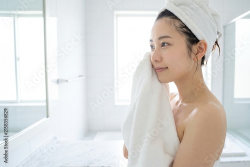 洗顔後にタオルで水分を拭き取る女性（素肌・清潔感・朝・スキンケア）