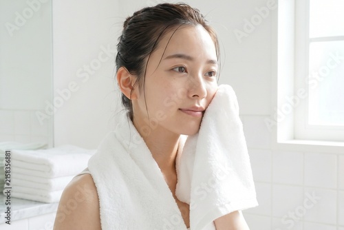 洗顔後にタオルで水分を拭き取る女性（素肌・清潔感・朝・スキンケア）