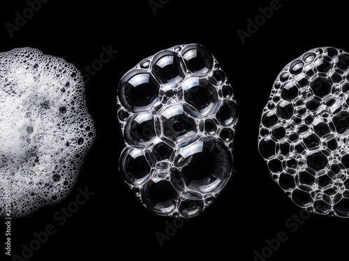 Macro foam bubbles on black background show varied soap suds sizes for cleaning products advertising and scientific visualization of liquid surface tension effects.