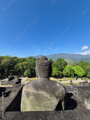 Obraz na płótnie Statue de Bouddha vue de dos face aux montagnes, temple de Borobudur, Indonésie