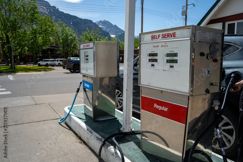 Fototapeta kuchenna Gas pumps at a self-serve station with mountains and trees in the scenic background on a clear day