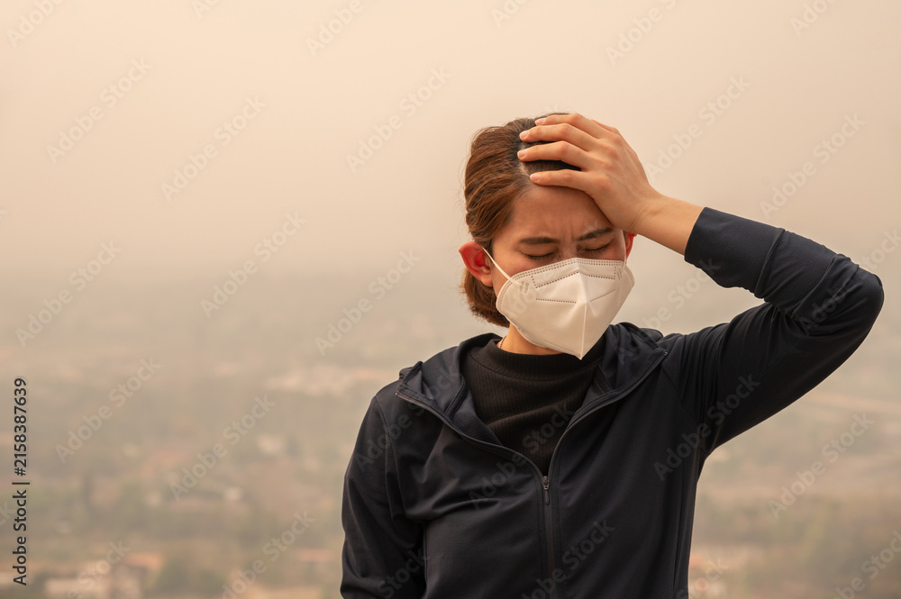 Naklejka premium Asian woman having headache becaused of by Bad air pollution (PM2.5). PM2.5 levels meaning the air quality posed a health hazard.
