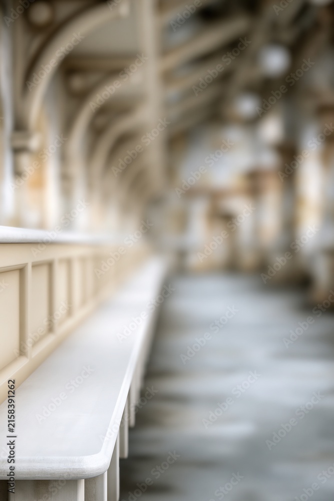 Fototapeta premium Blurred architectural interior with cream benches and arched ceiling structure in a historic building hallway.
