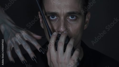 Intense Portrait of Man Holding Microphone with Mysterious Hand