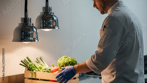 Chef inspecting fresh vegetables in kitchen
