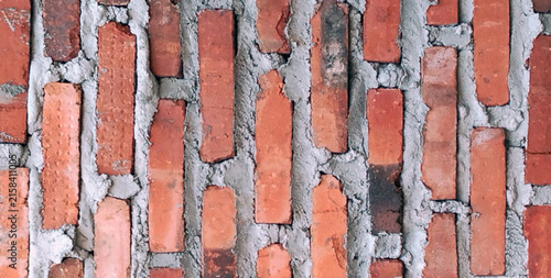 Obraz na płótnie Rustic Vertical Red Brick Wall with Rough Cement Mortar