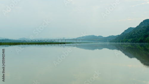 Tranquil River and Bridge with Mountain Reflections in Pengan County, Sichuan, China