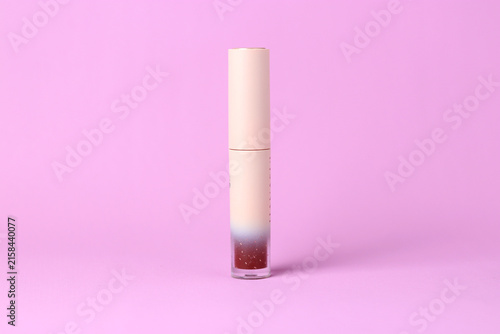 Minimalist cosmetic tube standing on a soft pink background
