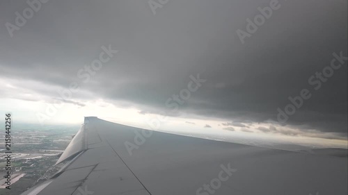 The wing of a large passenger plane floating in the sky during the rainy season.