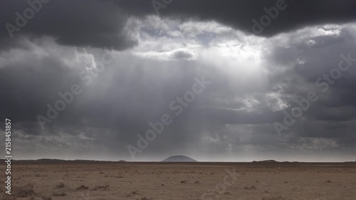Taklamakan Desert China storm clouds approach treeless sandy terrain in Xinjiang.