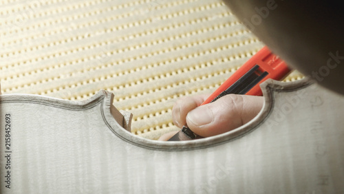 Fotografie Skilled craftsman carefully cutting wooden violin part, precise hand movements r