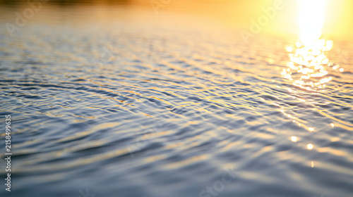 capturing gentle ripples on the surface of water during a golden hour. the su...