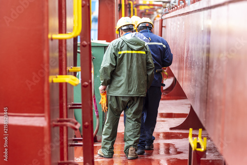 Industrial workers making their way along the deck of a newly constructed vessel before starting their assigned tasks in the shipyard.