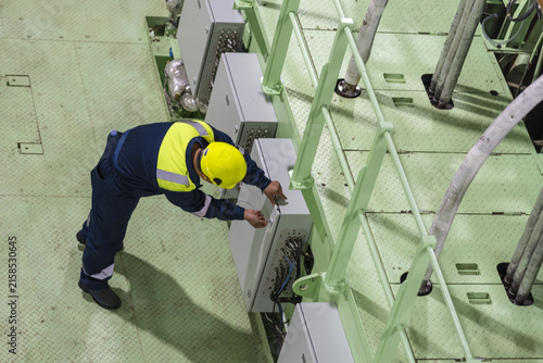 Maritime crew member performing a detailed inspection of a newly built ship before delivery, representing quality control and final vessel acceptance procedures.