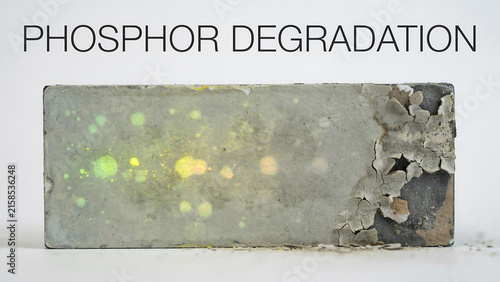 Close up view of a rectangular phosphor material showing significant degradation and physical surface damage over time