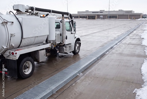 Heavy Duty Suction Vehicle Parked Near Drainage Infrastructure On Airport Tarmac