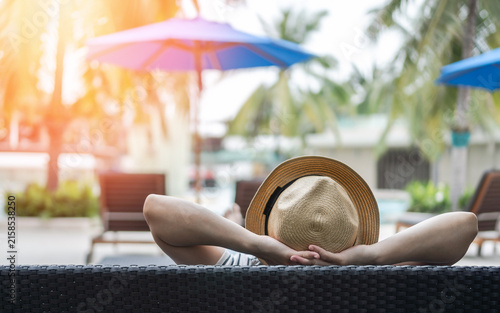 Summer resort hotel stay relaxation of business woman take it easy happily resting on beach chair on holiday travel vacation poolside in peacefully with tropical beach swimming pool
