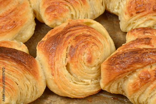 фотографія A close up shot of freshly baked golden brown puff pastry rolls and croissants o