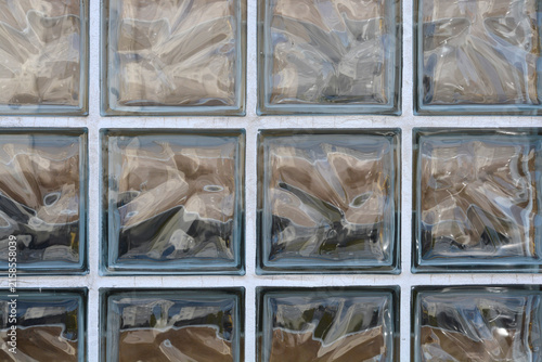 фотографія A full frame background texture showing a grid pattern of translucent square glass blocks with wavy internal patterns in a white wall