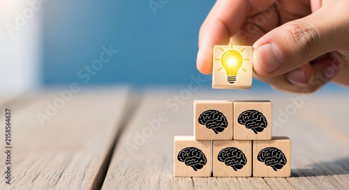 Hand placing a lightbulb block on top of stacked brain blocks symbolizing innovative ideas and creative thinking in a modern workspace scene