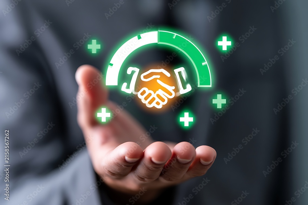 Fototapeta premium Businessman holding a digital partnership trust level meter with handshake icon. Concept of business collaboration, successful partnership, corporate trust, joint ventures, and mergers.