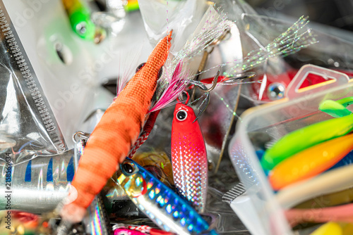 Bild auf Leinwand Orange squid jig and colorful metal fishing lures in tackle box The Concept of s