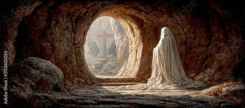 Figure draped in white cloth seated inside a cave, illuminated by soft light with a cross visible in the background, creating a serene and contemplative atmosphere